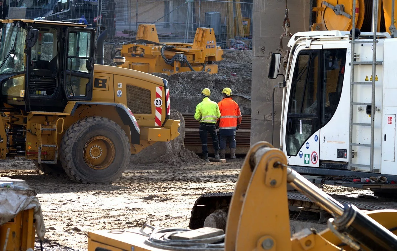 Photo d'un chantier de BTP avec des engins de chantier et deux ouvriers