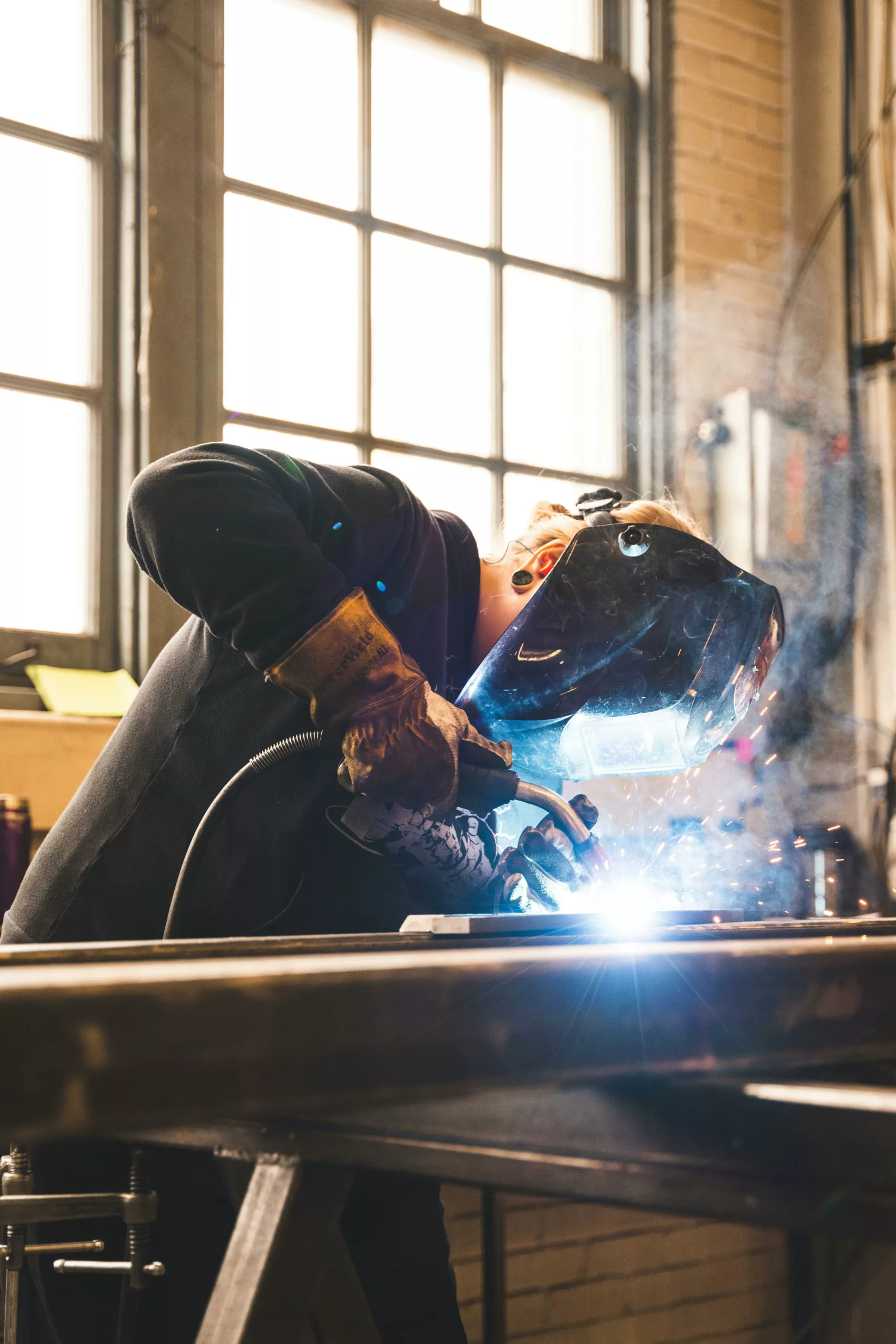 Ovrier qui réalise une soudure dans un atelier.