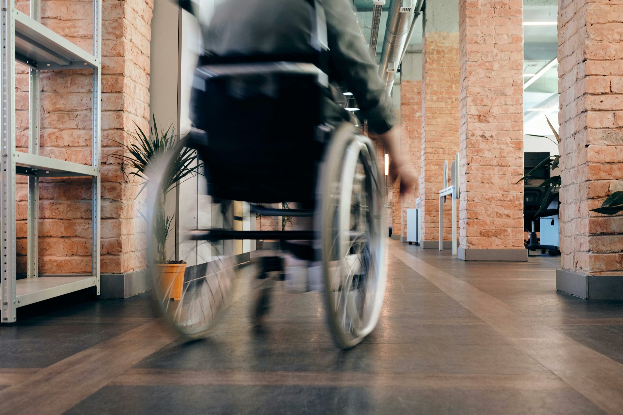 Personne en fauteuil roulant dans un couloir